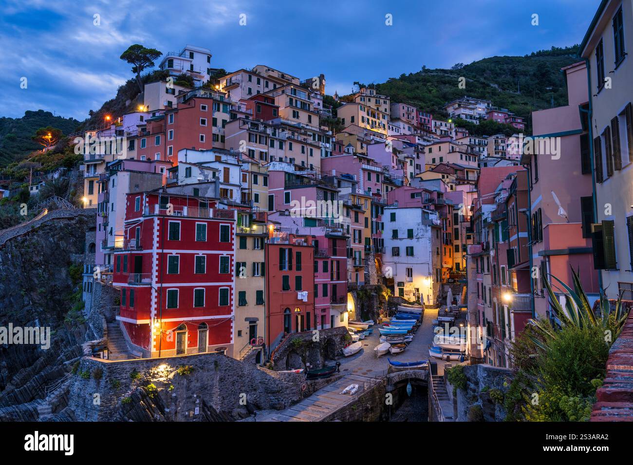 Crepuscolo presso il pittoresco villaggio di pescatori di Riomaggiore nel Parco Nazionale delle cinque Terre nella regione Liguria del nord-ovest Italia Foto Stock