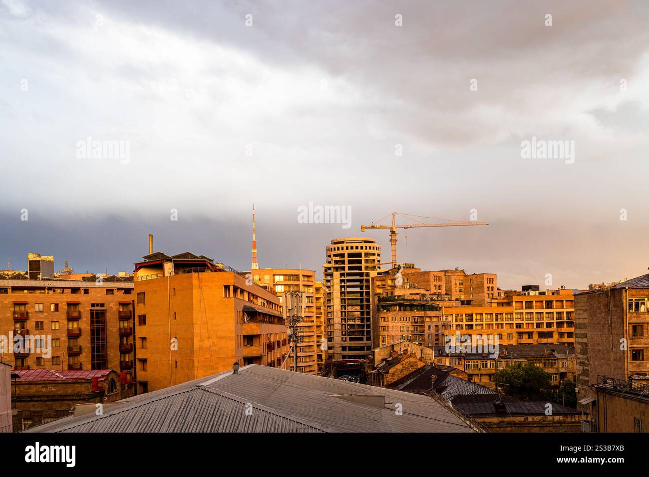 Nuvoloso cielo serale sull'area residenziale della città di Erevan in Armenia al tramonto arancione Foto Stock