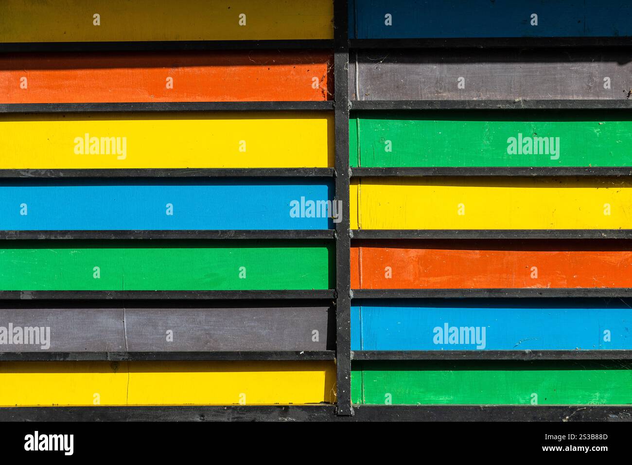 Tavole di legno multicolore sulle pareti della casa nella città di Dilijan, Armenia, nelle soleggiate giornate estive Foto Stock