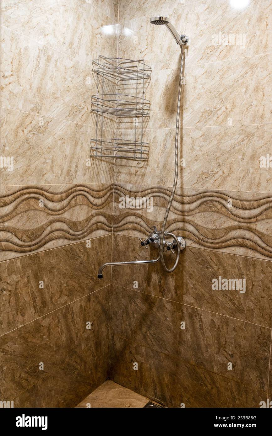 cabina doccia in rustica pensione rivestita con piastrelle in ceramica marrone Foto Stock