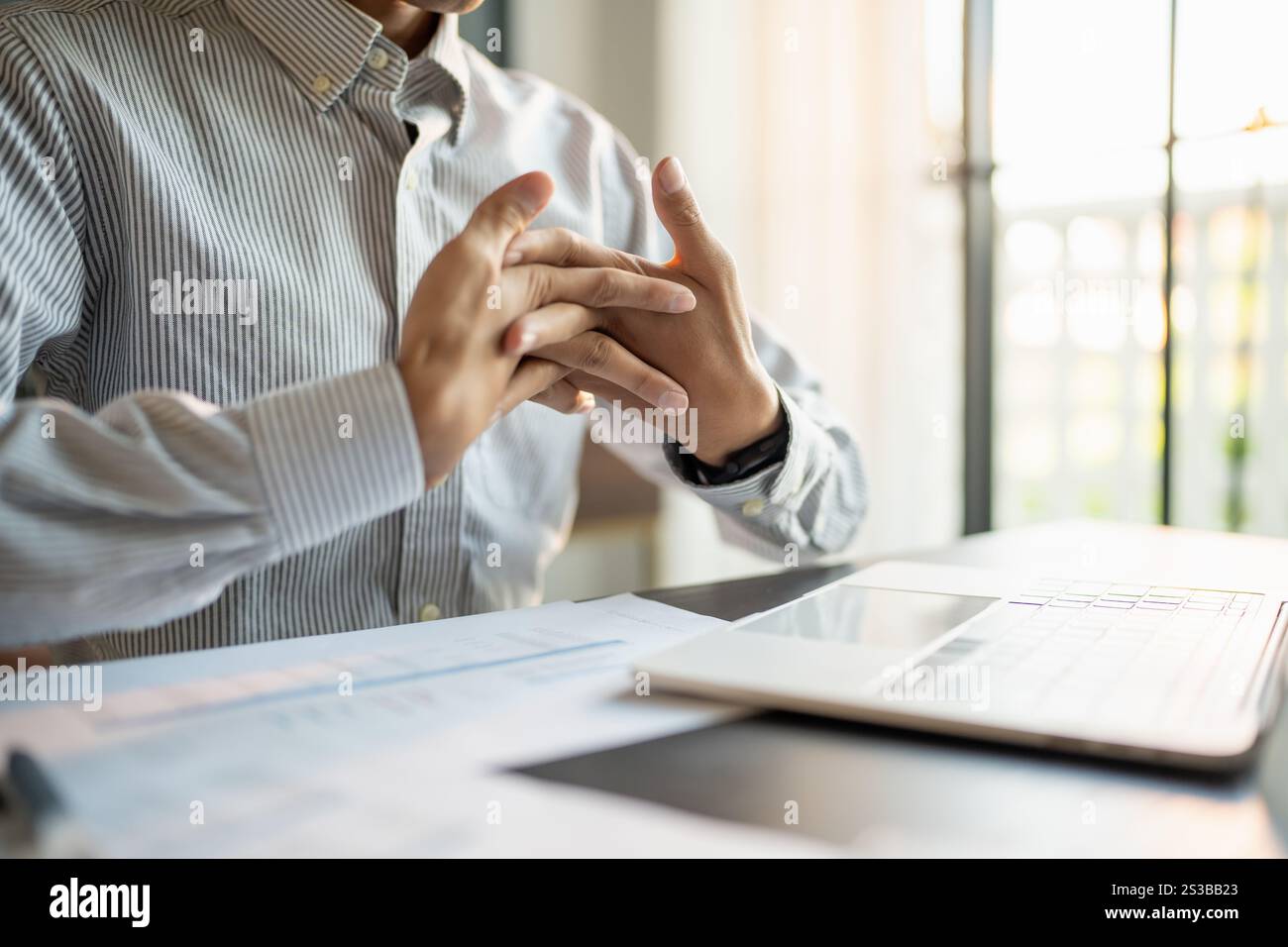Uomo d'affari Stretch muscoli delle mani prima di lavorare a lungo. Stanco uomo d'affari che si allunga le braccia e lavora nel tempo in ufficio Foto Stock