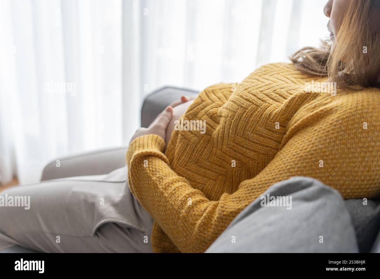 Donna incinta tiene le mani sulla pancia toccando il suo bambino curando la sua salute bella donna incinta felice tenera umore foto di gravidanza. Foto Stock