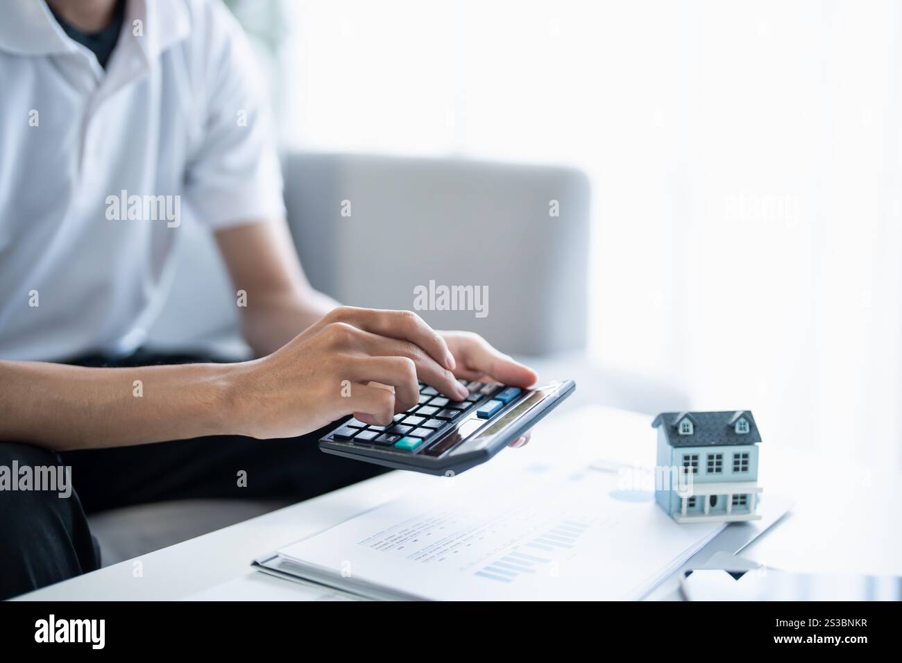 L'uomo calcola le finanze casa paga bollette tasse risparmio economia finanziaria a casa. Foto Stock