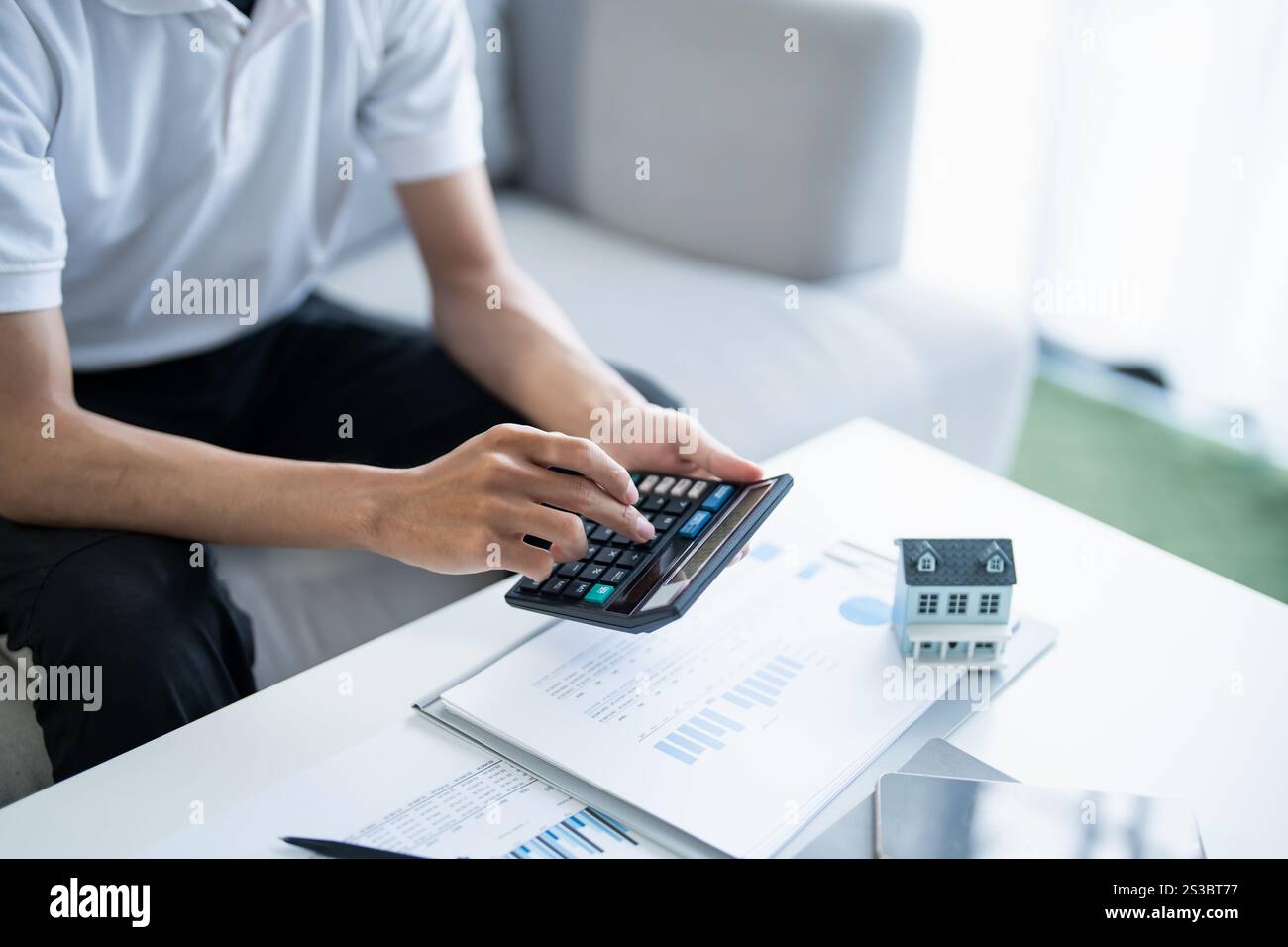 L'uomo calcola le finanze casa paga bollette tasse risparmio economia finanziaria a casa. Foto Stock