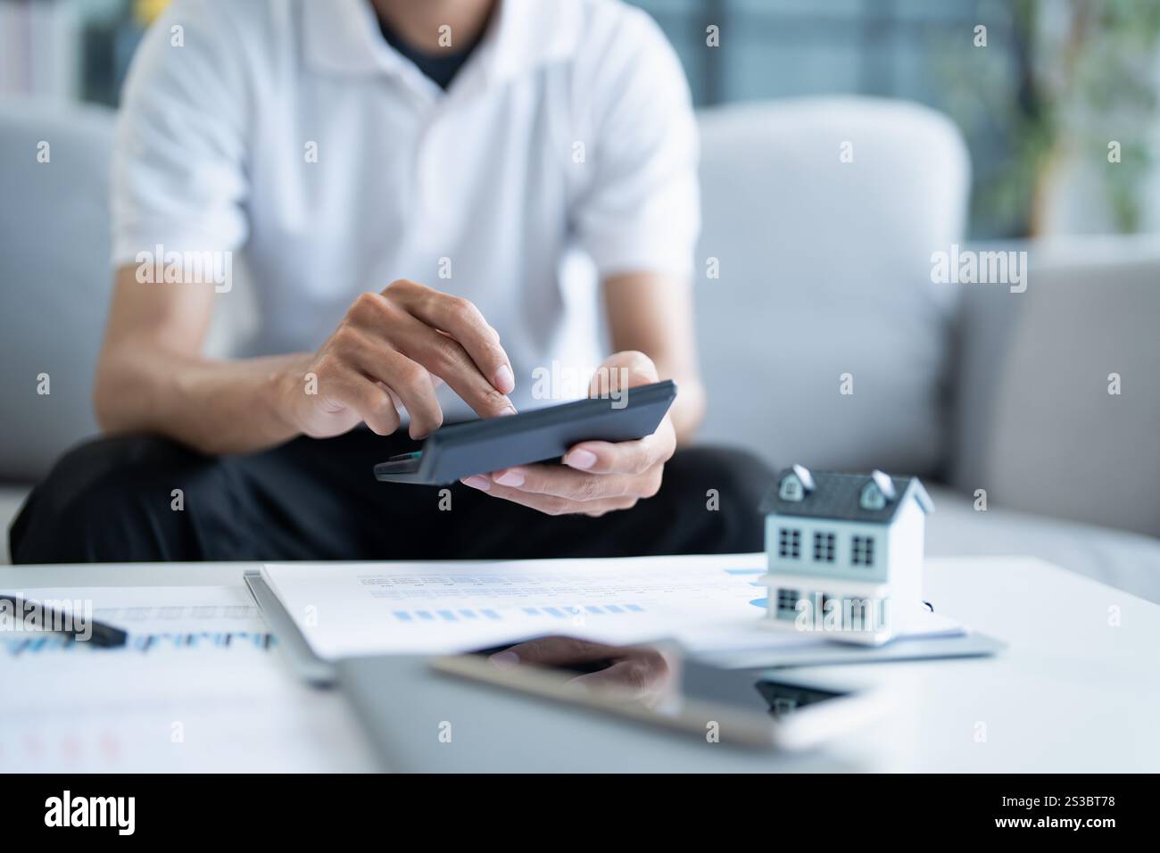 L'uomo calcola le finanze casa paga bollette tasse risparmio economia finanziaria a casa. Foto Stock