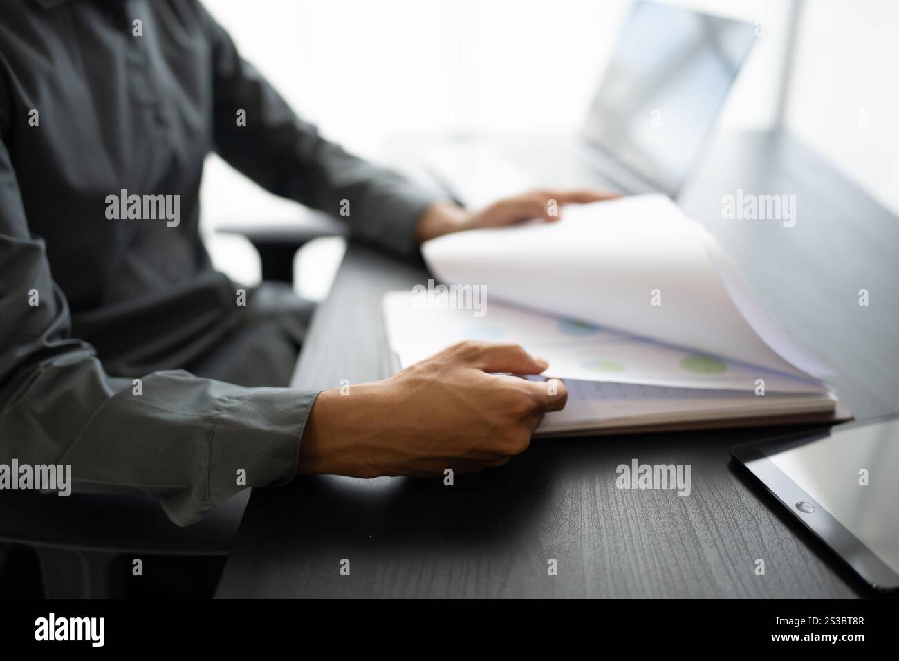 Uomo d'affari asiatico in possesso di un documento cartaceo che calcola il bilancio di gestione dell'assicurazione fiscale Foto Stock