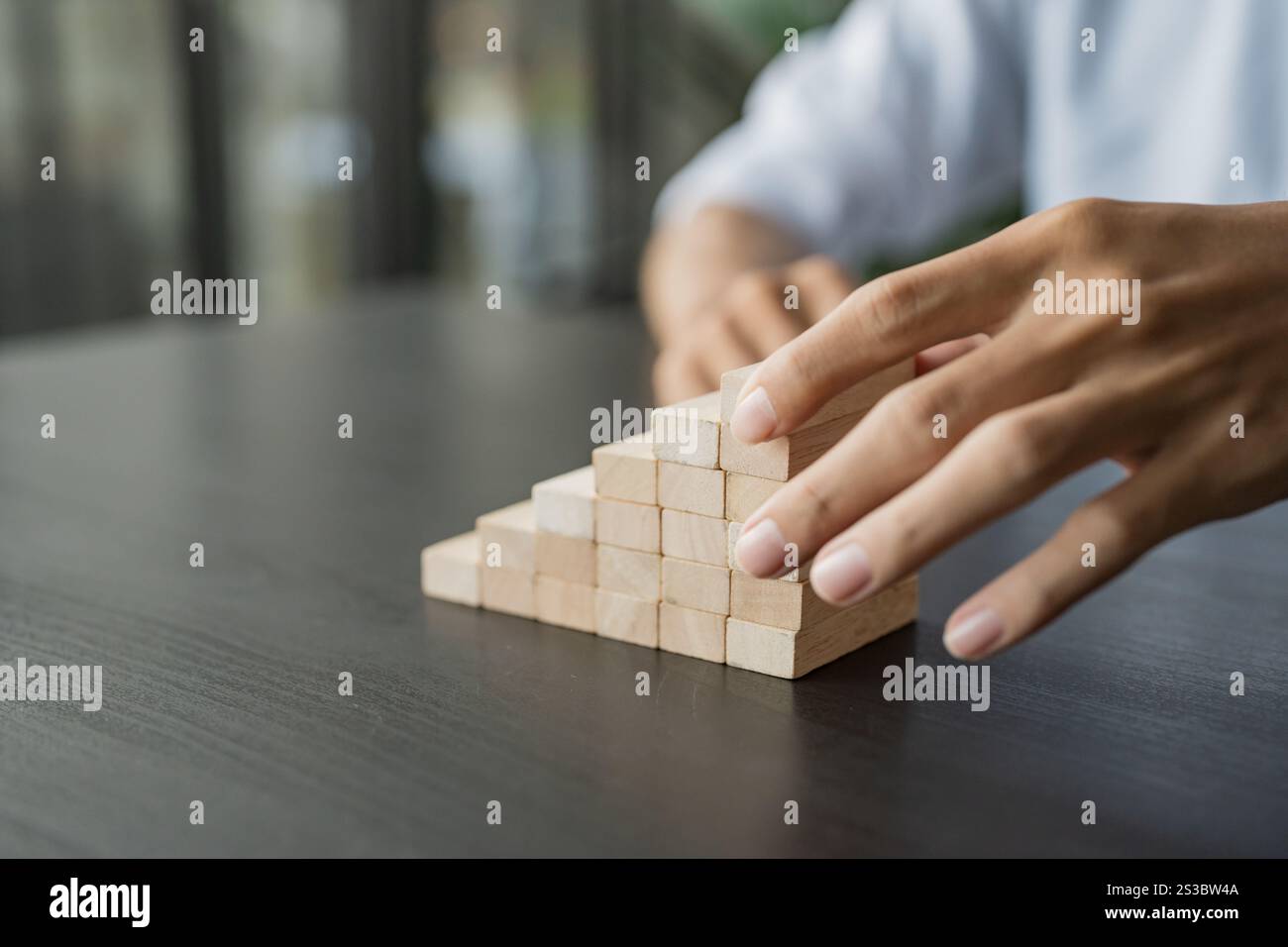 Processo di successo della crescita aziendale gestione delle scale di impilamento dei blocchi di legno concetto di strategia aziendale Foto Stock