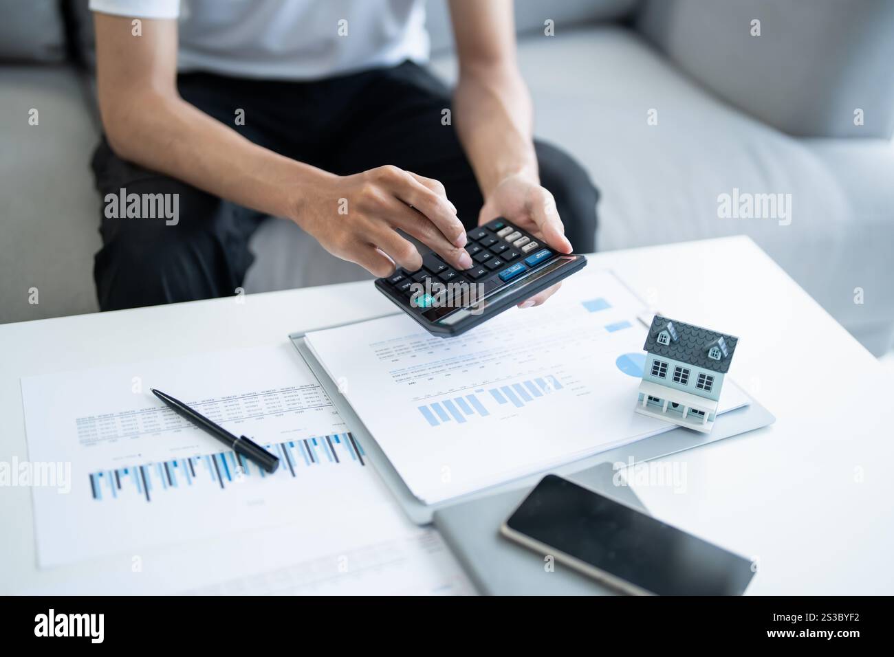 L'uomo calcola le finanze casa paga bollette tasse risparmio economia finanziaria a casa. Foto Stock