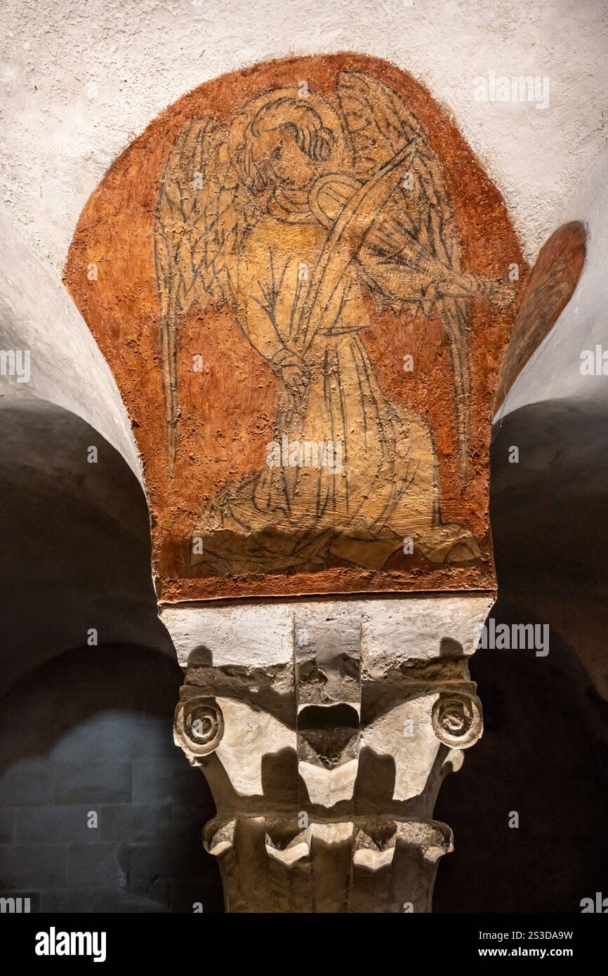 Pittura murale gotica medievale del XV secolo di un angelo che suona musica sopra un capitello di colonna in pietra nella cripta della cattedrale di Bayeux, Normandia, Francia Foto Stock