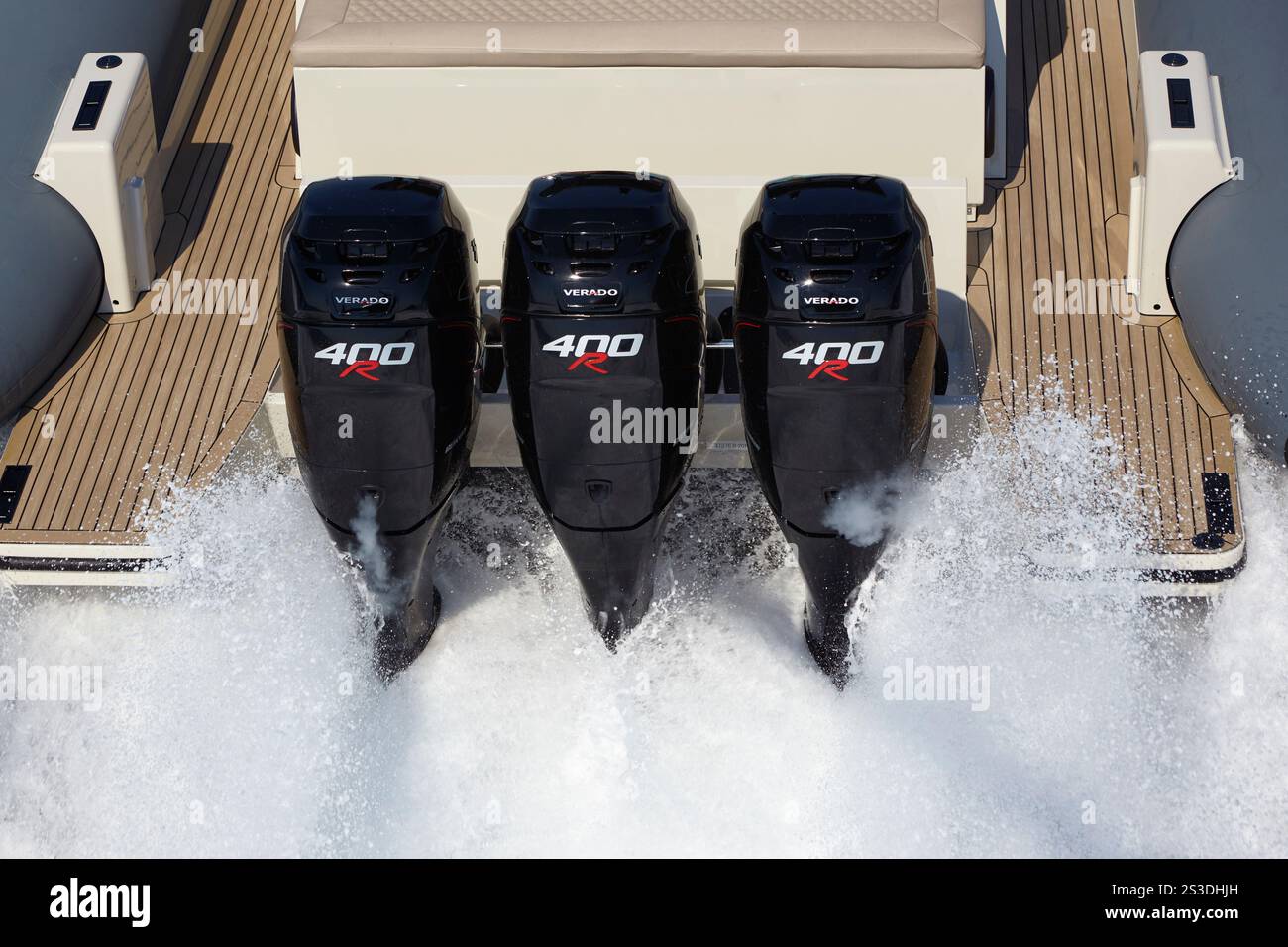 Potenti motori fuoribordo triplo da 400 CV che alimentano un elegante e moderno motoscafo ad alta velocità sul mare. Foto Stock
