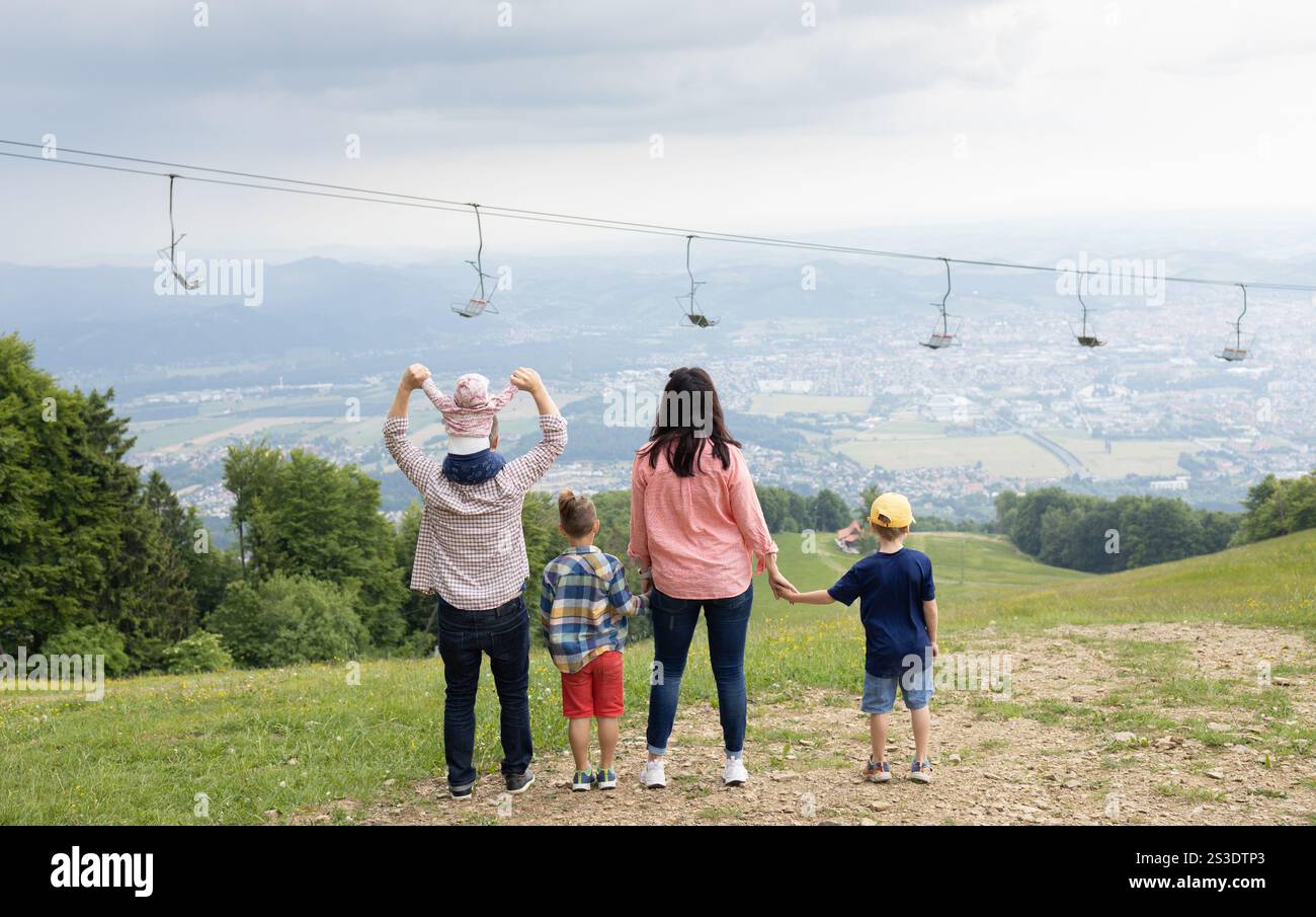 famiglia irriconoscibile e affiatata di cinque persone, due adulti e tre bambini che fanno escursioni in montagna. disintossicazione digitale, fine settimana in natura, insieme in famiglia. E Foto Stock