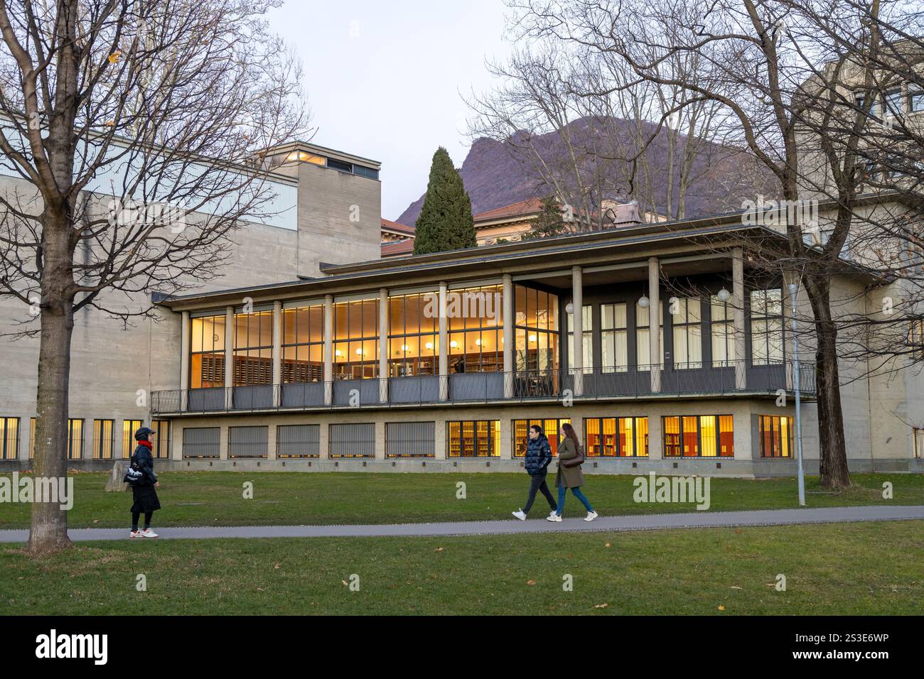 Lugano, Svizzera - 23 dicembre 2024: Persone che camminano nel Parco Ciani, con alle spalle la Biblioteca Cantonale Lugano Foto Stock