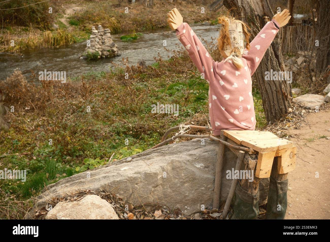 Sedia unica a forma di spaventapasseri sul fiume creek Foto Stock