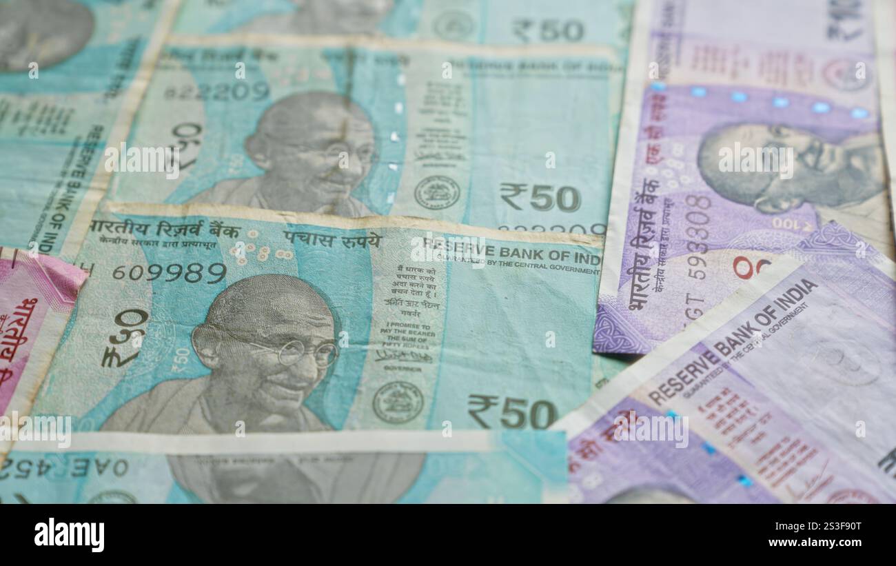 Banconote indiane con mahatma gandhi giacciono sparse, mostrando diversi tagli di rupie. Foto Stock