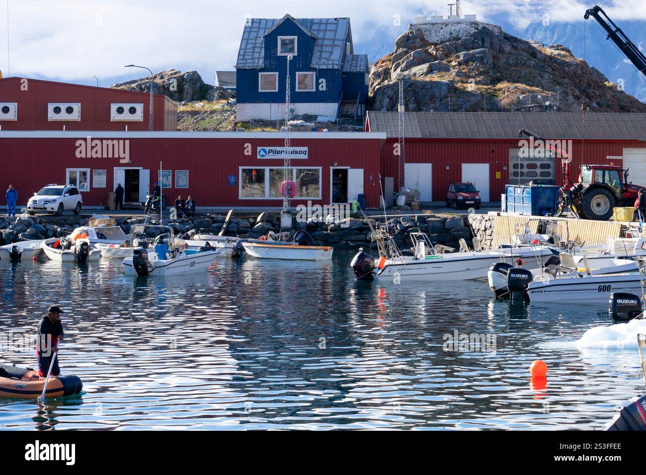 Scena quotidiana in un porto con barche da pesca e un negozio locale Pillersuisoq. Uummannaq, Avannaata, Groenlandia occidentale, Danimarca Foto Stock