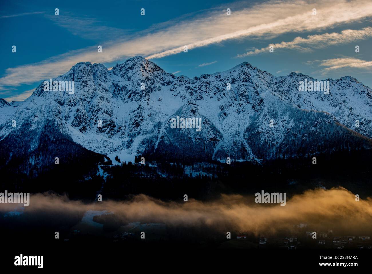 La nebbia avvolge le montagne al tramonto Foto Stock