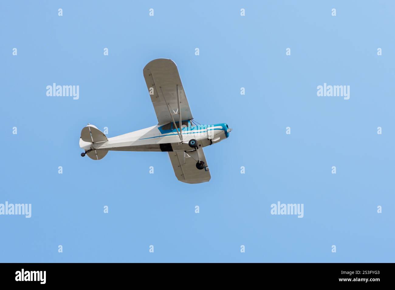 Piccolo aereo che vola sopra il cielo blu. Foto Stock