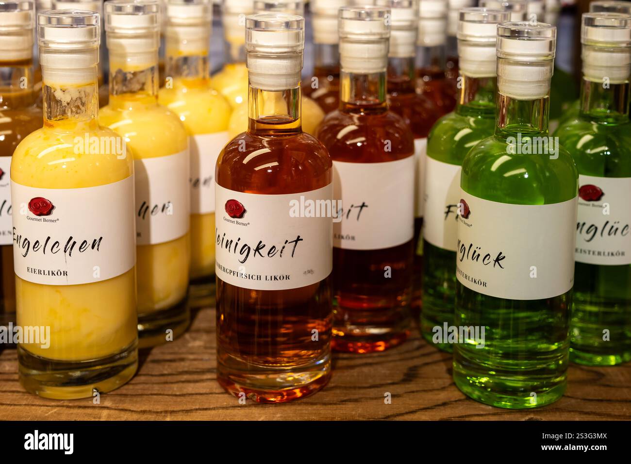 Fussen, Germania 11 novembre 2024, assortimento di liquori colorati su ripiano in legno Foto Stock