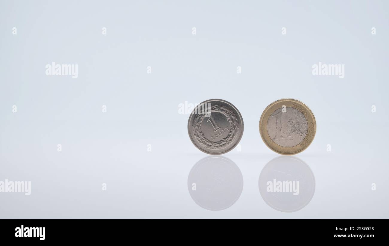 Monete da 1 Zloty e 1 Euro affiancate su sfondo minimalista Foto Stock
