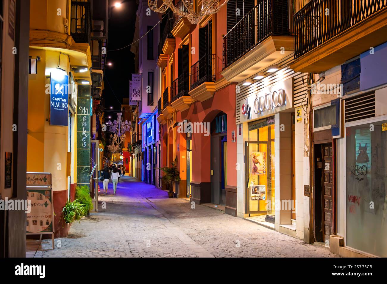 Vista notturna del casco Antiguo, o quartiere antico, il quartiere centrale di Siviglia, noto per le sue strette strade acciottolate piene di negozi. Foto Stock