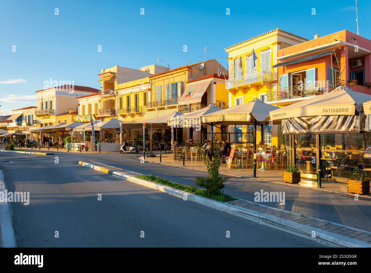 La strada principale che attraversa il pittoresco villaggio di Egina, sull'isola di Egina in Grecia nel Golfo Saronico vicino ad Atene. Foto Stock