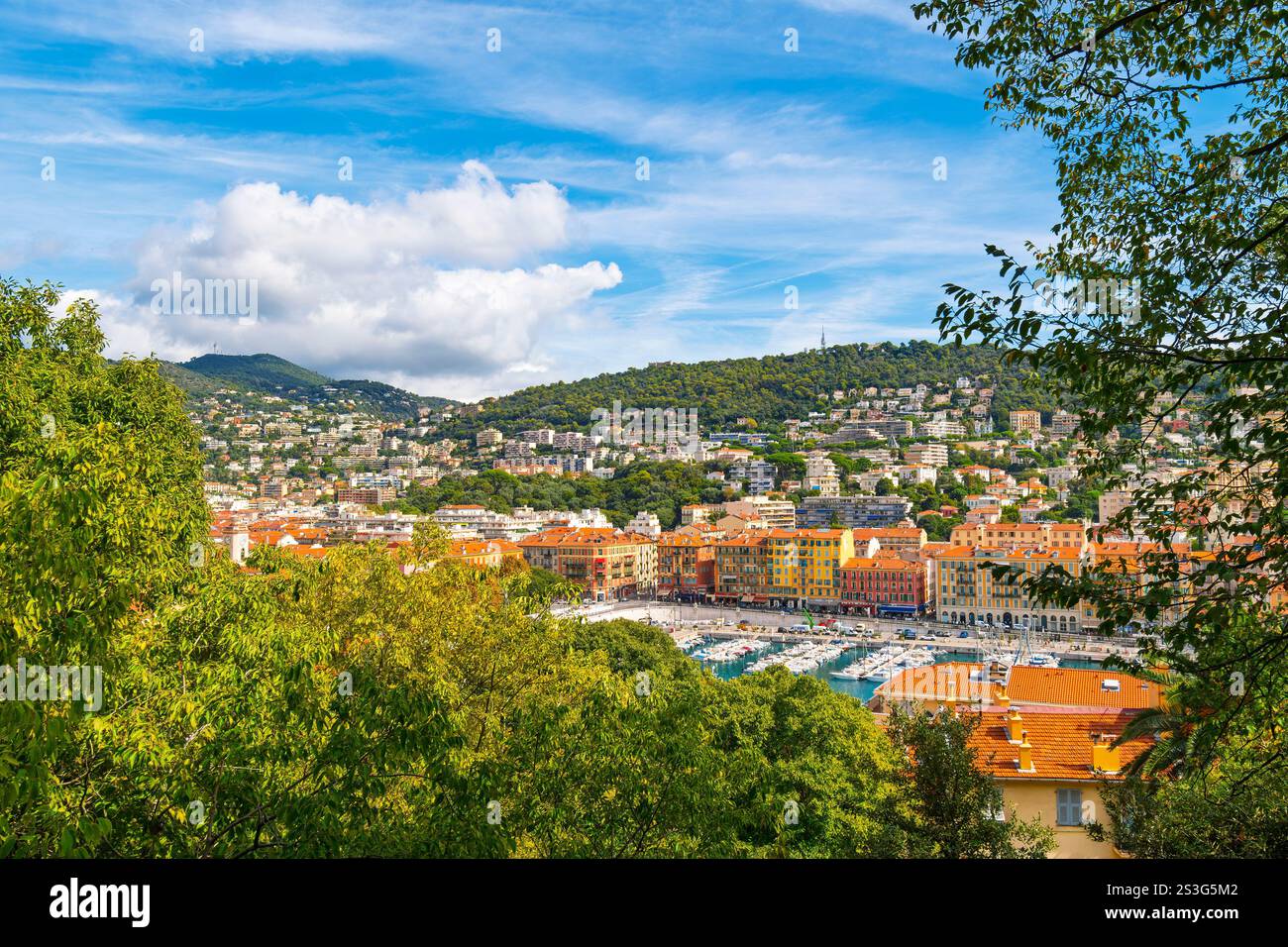 Ammira gli alberi dalla collina del Castello del Vecchio Porto di Lympia, con colorati edifici sul lungomare e barche nel porto turistico di Nizza, Francia. Foto Stock
