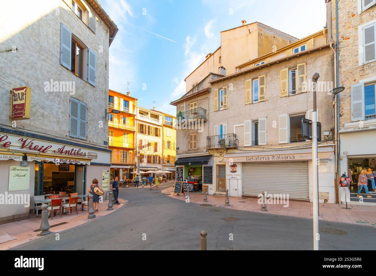 Negozi colorati e caffetterie lungo la storica Rue de la Republique nella pittoresca città vecchia di Antibes, Francia, Costa Azzurra. Foto Stock