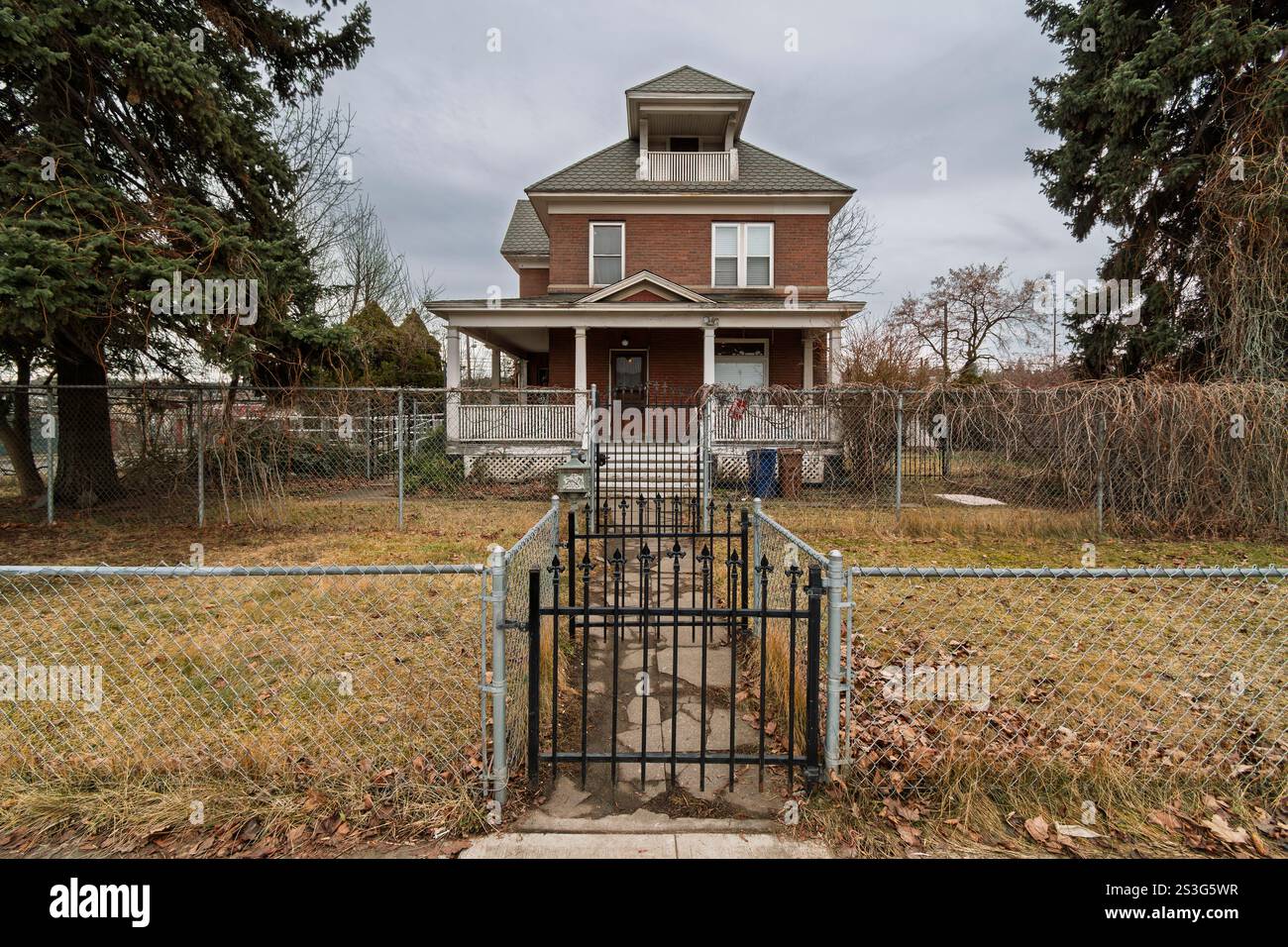 Una grande casa vittoriana con cancelli in mattoni in rovina nel centro di Spokane, Washington USA. Foto Stock