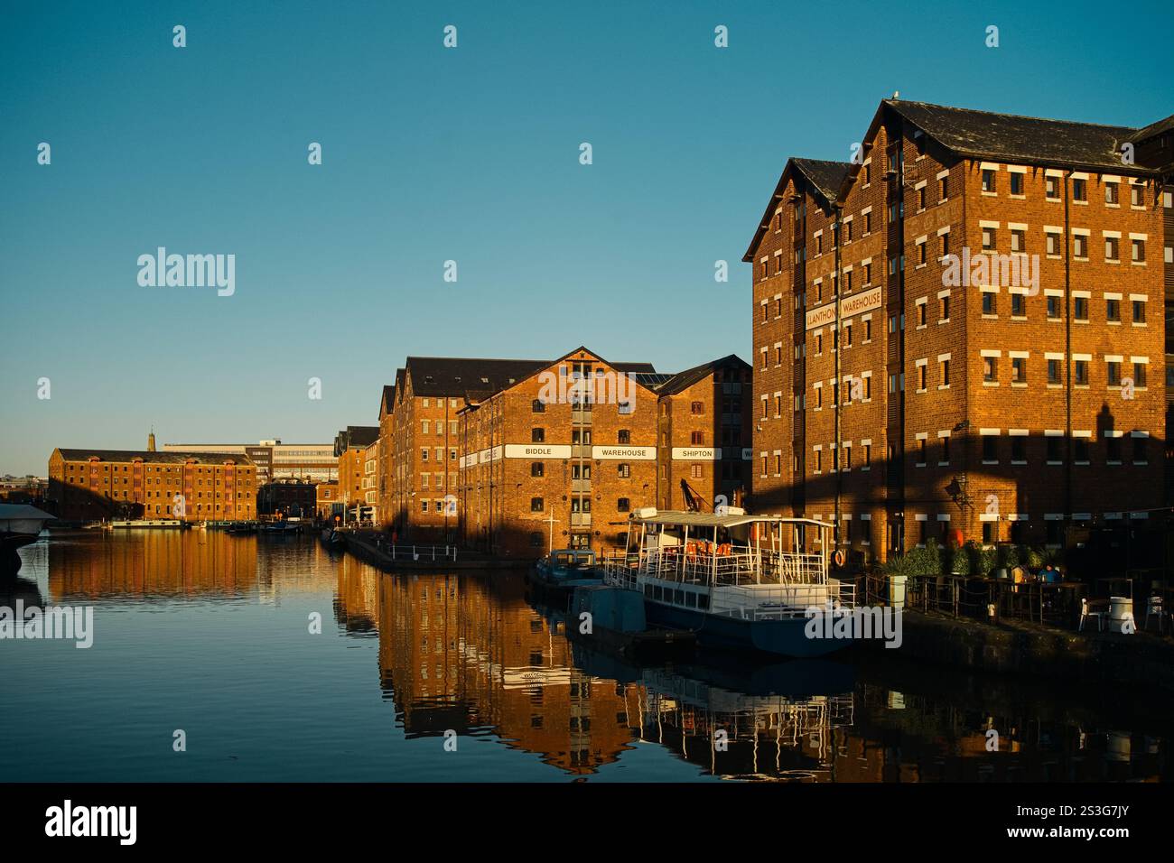 Un'affascinante scena urbana con lo storico Gloucester Quays. Il riflesso degli edifici nell'acqua. Giornata di sole. Foto Stock