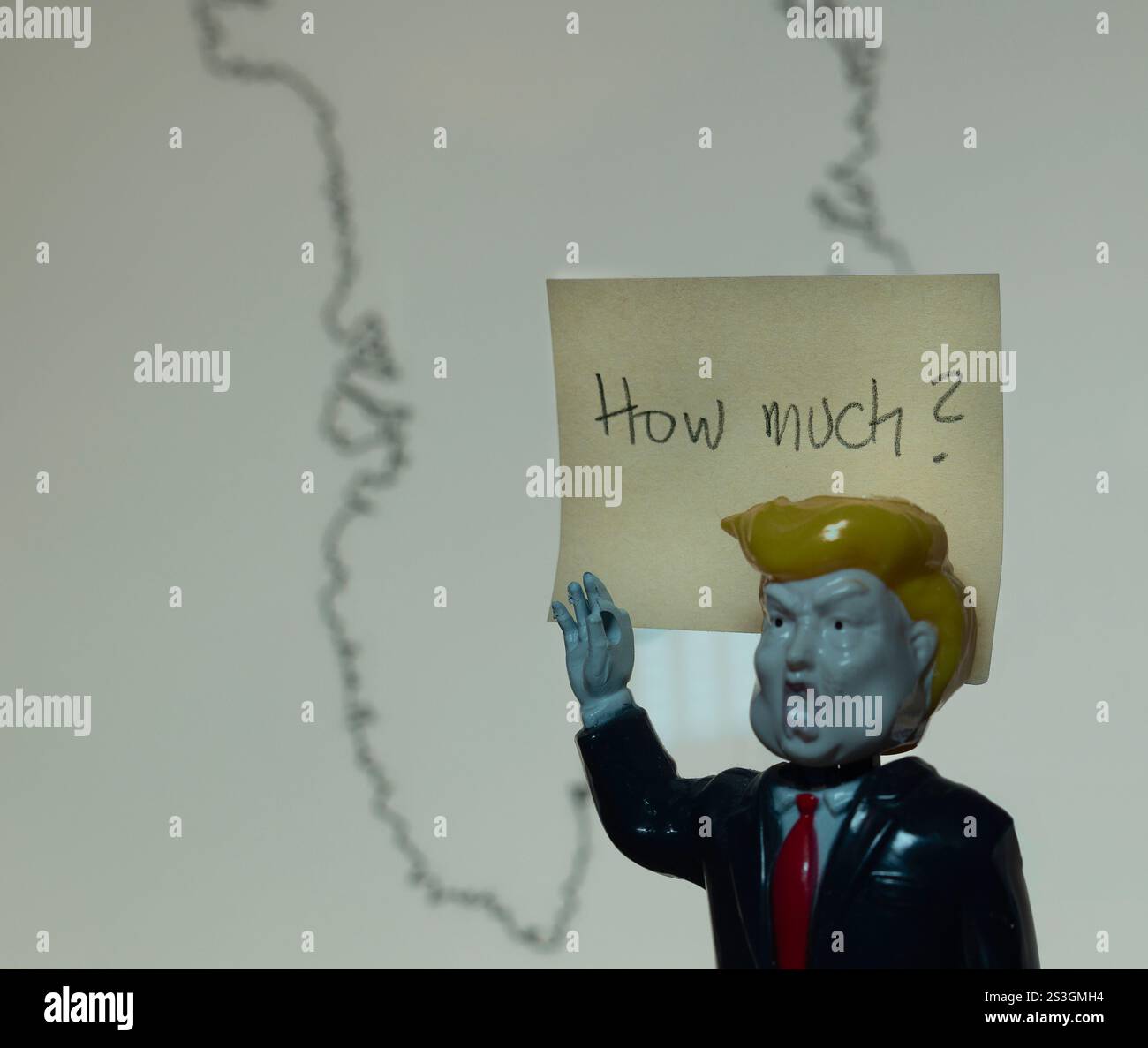 Giocattolo di plastica di Donald Trump con un cartello davanti alla mappa della Groenlandia, Danimarca, 9 gennaio 2025 Foto Stock