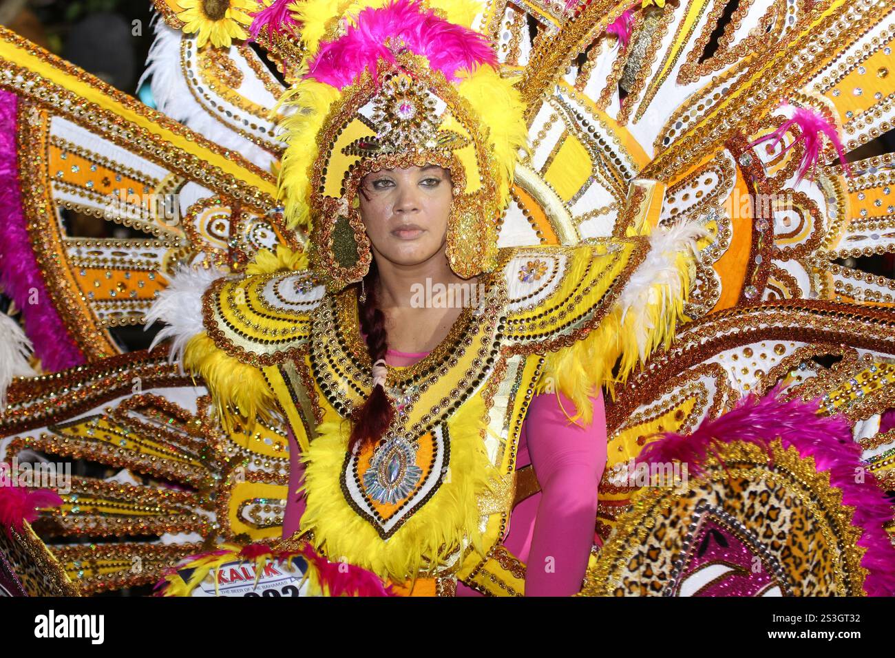 Una donna nera vestita con un costume d'oro con ali rosse e blu al Carnevale di Junkanoo Street di Capodanno che si tiene alle Bahamas Foto Stock