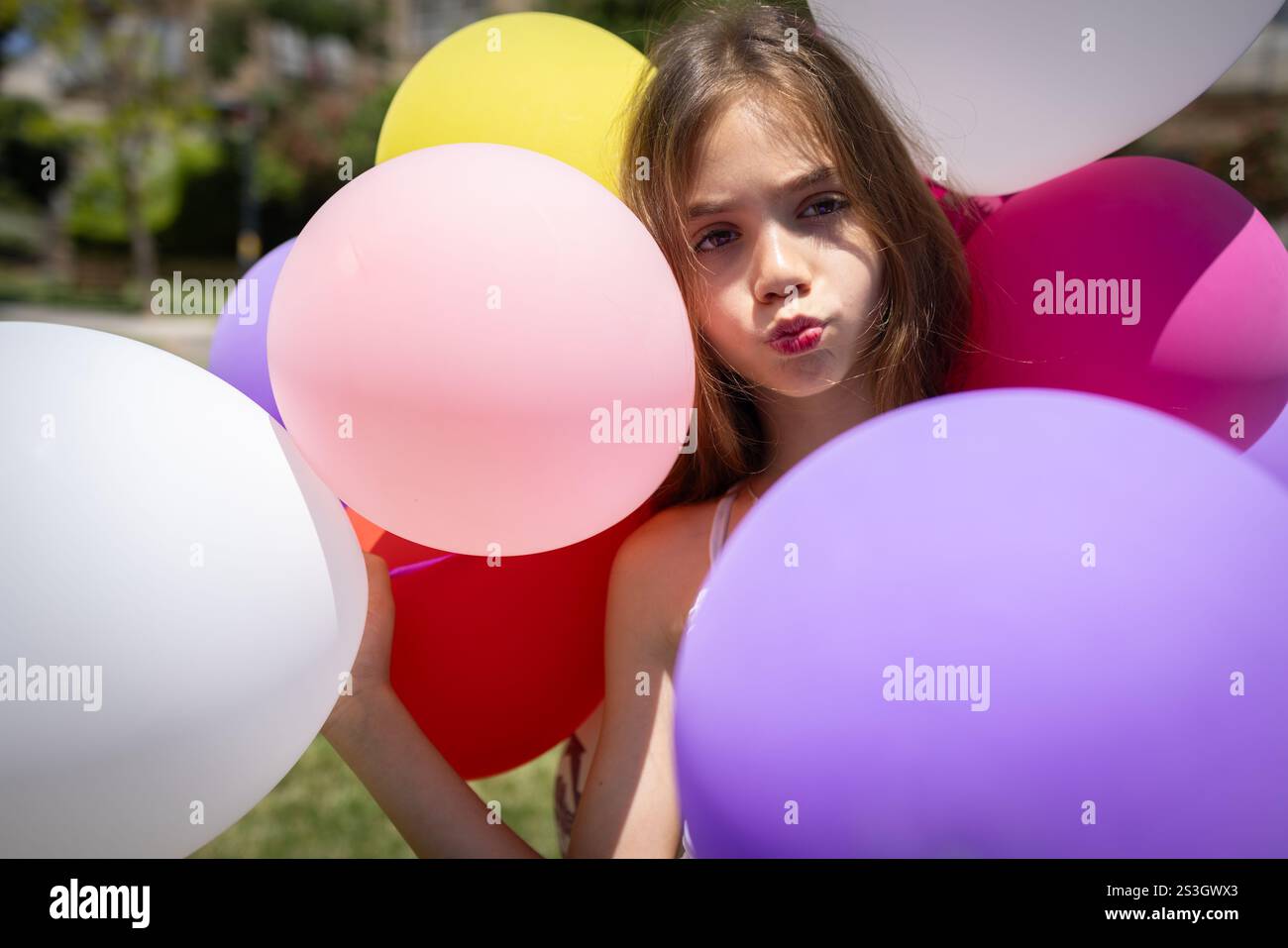 Primo piano di una ragazza con palloncini di dieci anni che dà un bacio ottimo per la moda e il concetto di stile di vita Foto Stock