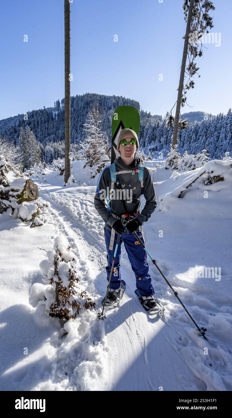 Ciaspole in una foresta invernale innevata, salita al Teufelstaettkopf, paesaggio di montagna innevata, Alpi Ammergau, Baviera, Germania, Europa Foto Stock