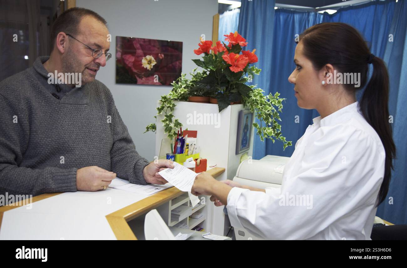 Il paziente riceve una prescrizione dall'assistente medico Foto Stock