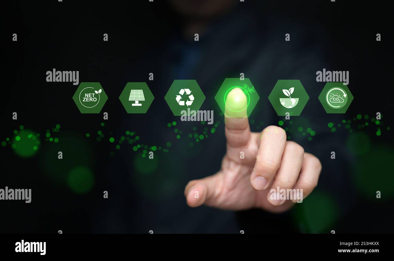 Concetto di energia verde. Un uomo attiva o tocca icone di fonti di energia rinnovabili sostenibili Foto Stock