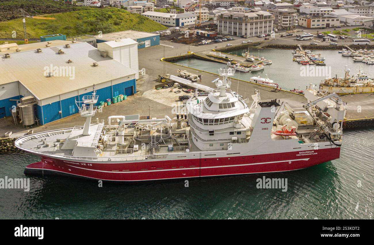 Isola di Heimaey, Islanda: Vista aerea con drone, peschereccio SIGURDUR (p Pinnone), porto di Vestmannaeyjar, porto industriale della pesca, Atlantico settentrionale Foto Stock