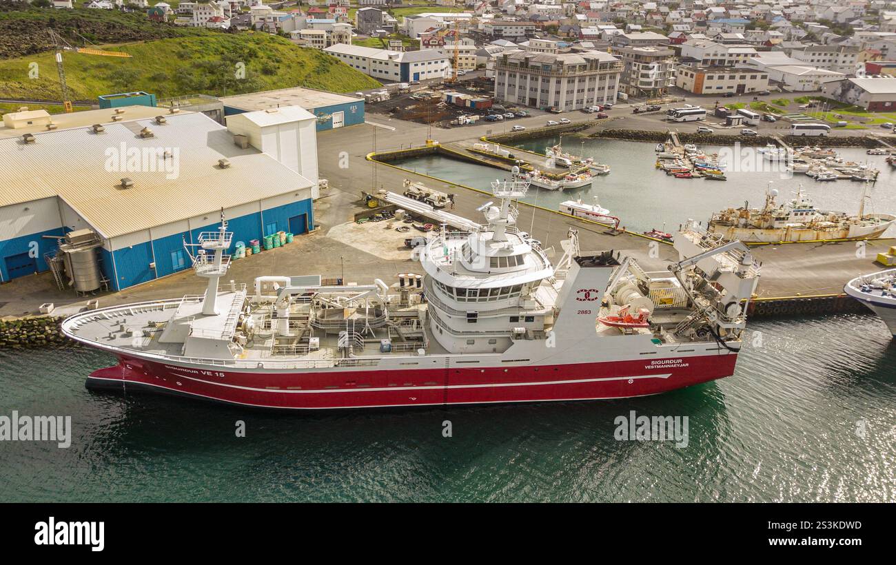 Isola di Heimaey, Islanda: Vista aerea con drone, peschereccio SIGURDUR (p Pinnone), porto di Vestmannaeyjar, porto industriale della pesca, Atlantico settentrionale Foto Stock