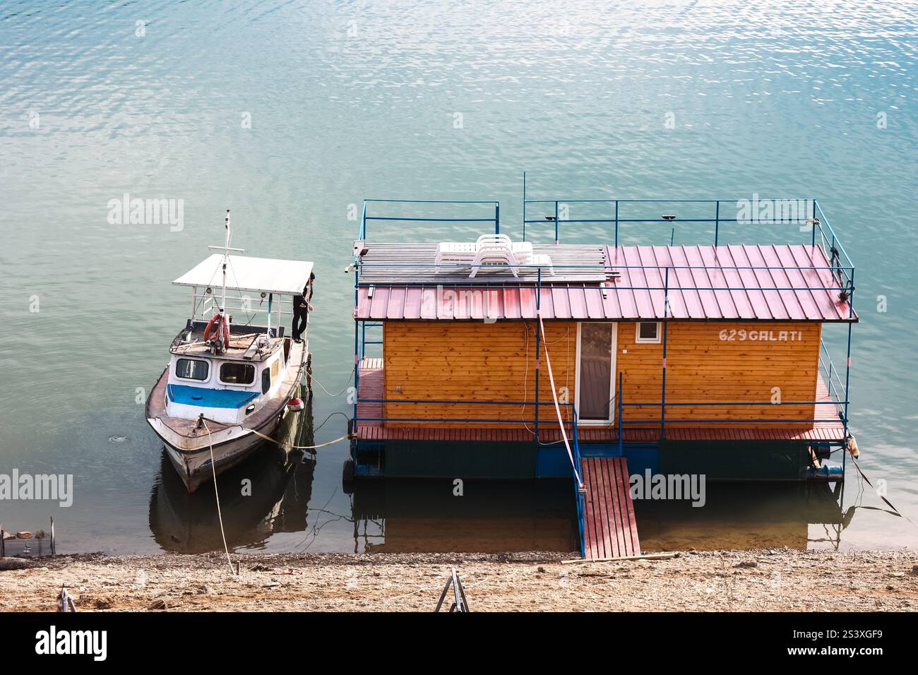 La casa galleggiante dei pescatori sul lago. Barca vicino alla casa. Stagione di pesca. Bicaz, Romania Foto Stock