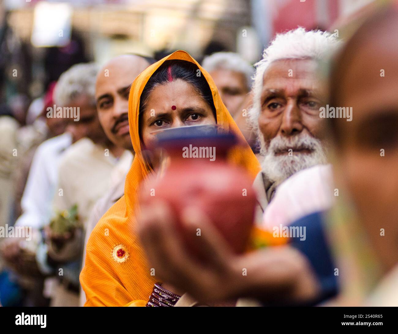 Anziani e famiglie si riuniscono in una festa in una strada vivace durante un evento culturale in India Foto Stock