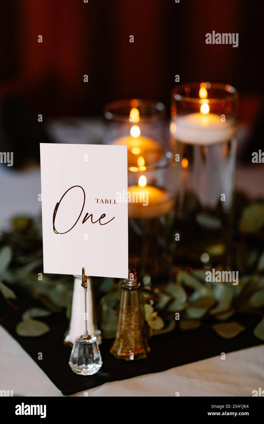Elegante carta "Table One" con candele accese e decorazioni in verde Foto Stock