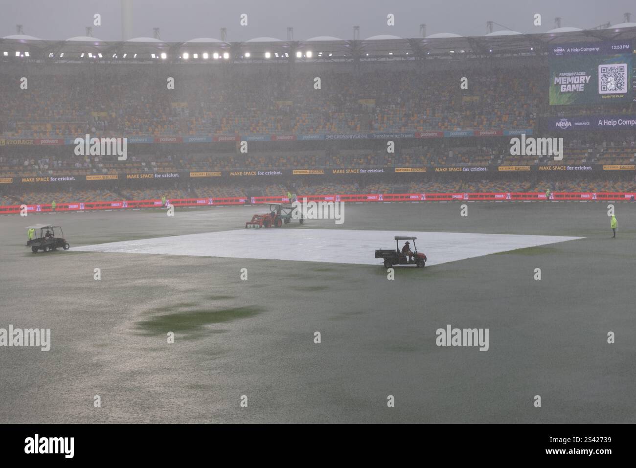 Il personale di terra in Action Heavy Rain interrompe il test Match al Gabba Foto Stock