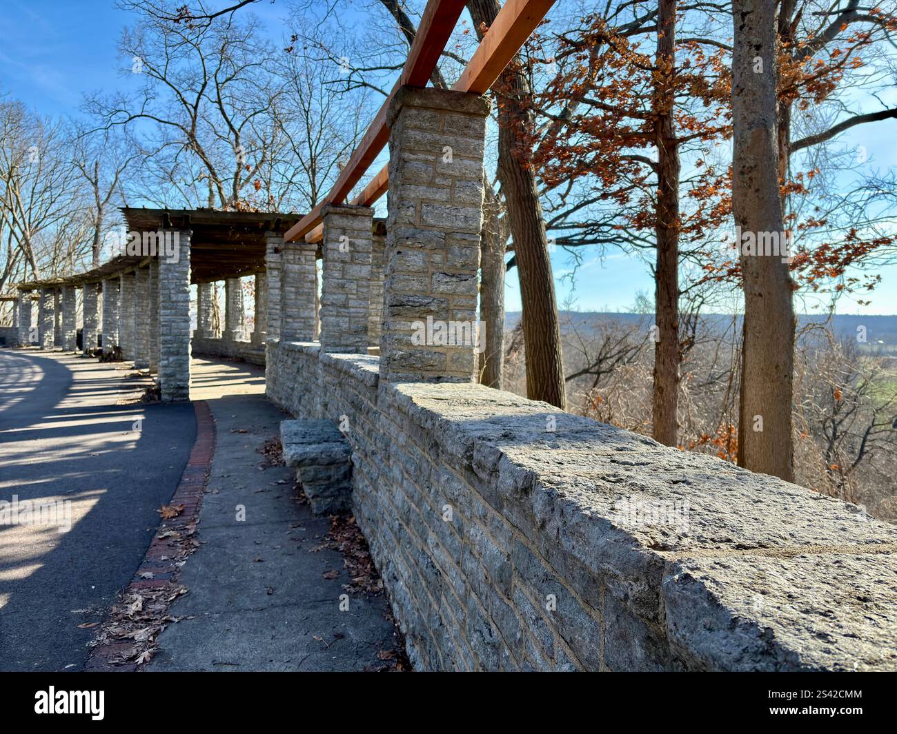 Pergola in pietra con travi in legno, sentiero curvo, vista panoramica del bosco Foto Stock