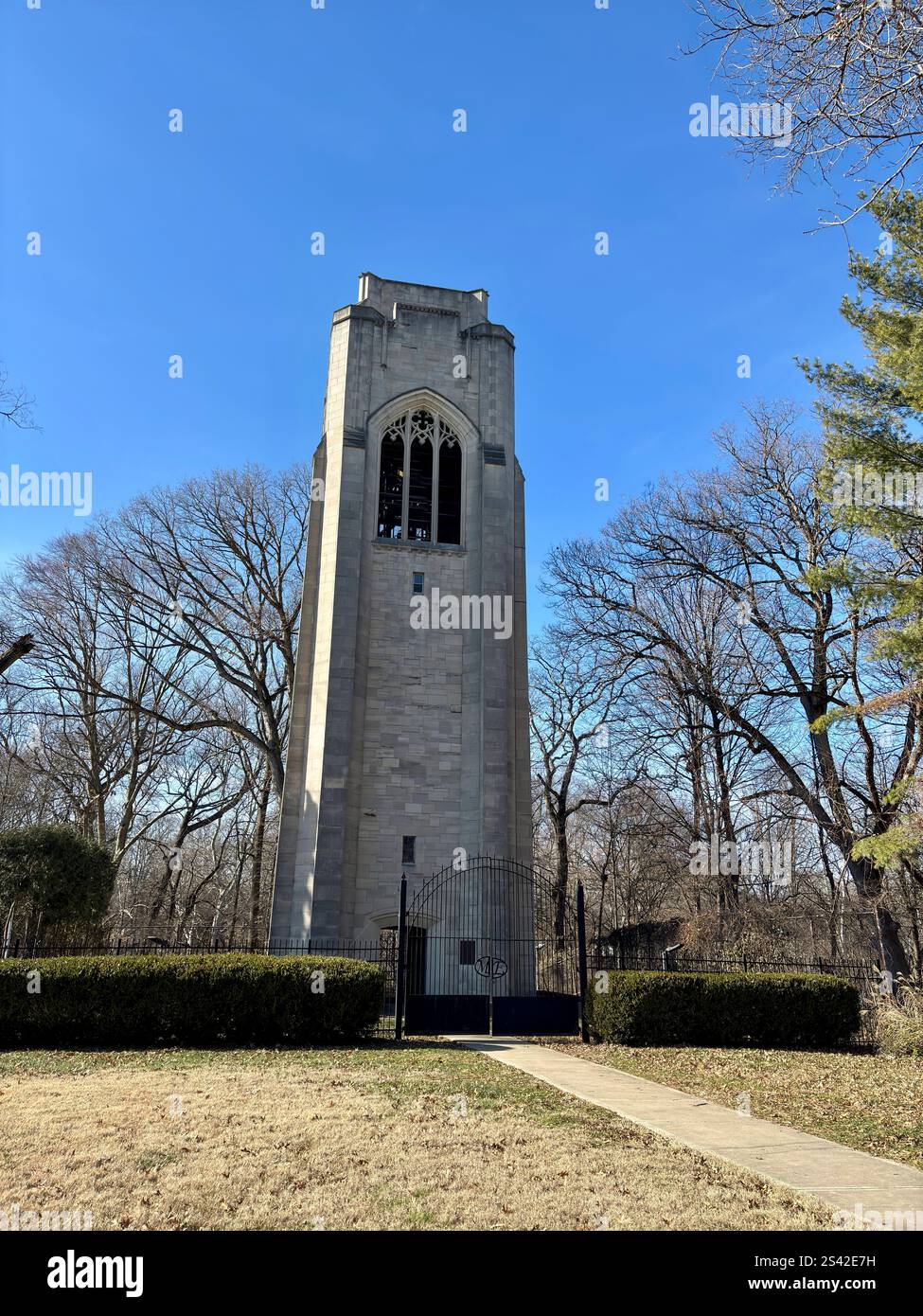 Campanile in pietra con finestre in stile gotico, circondato da alberi Foto Stock Campanile in pietra con finestre in stile gotico, circondato da alberi Foto Stock