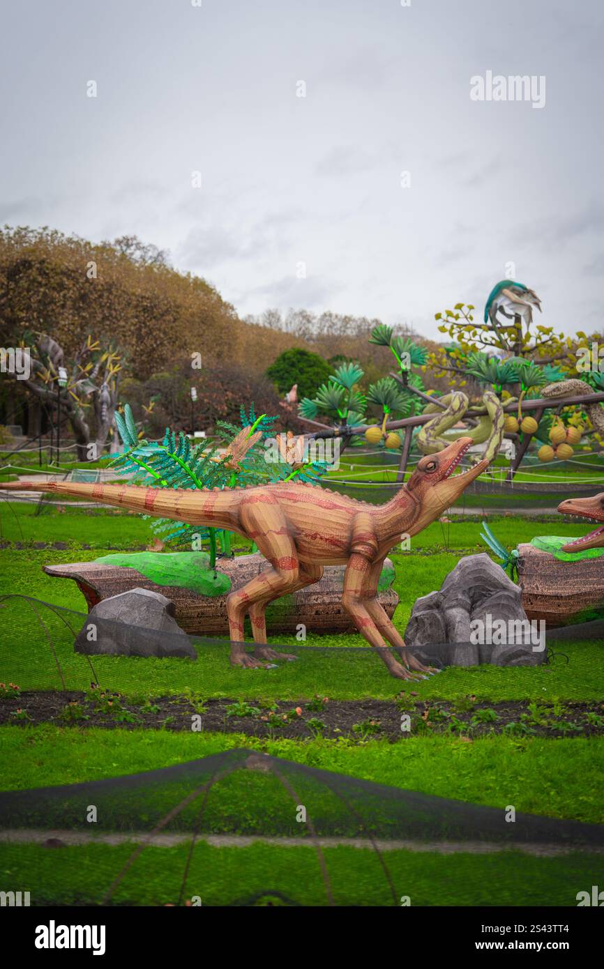 Sculture di dinosauri in un giardino lussureggiante esibiscono durante una giornata nuvolosa Foto Stock