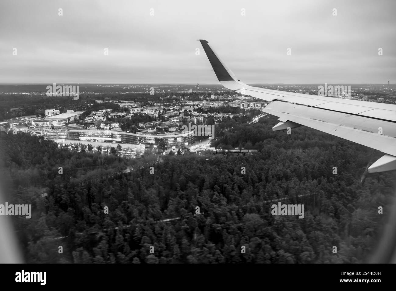 Vista di una città attraverso l'oblò di un aereo mentre si prepara ad atterrare, in una mattina d'inverno presto. Foto Stock