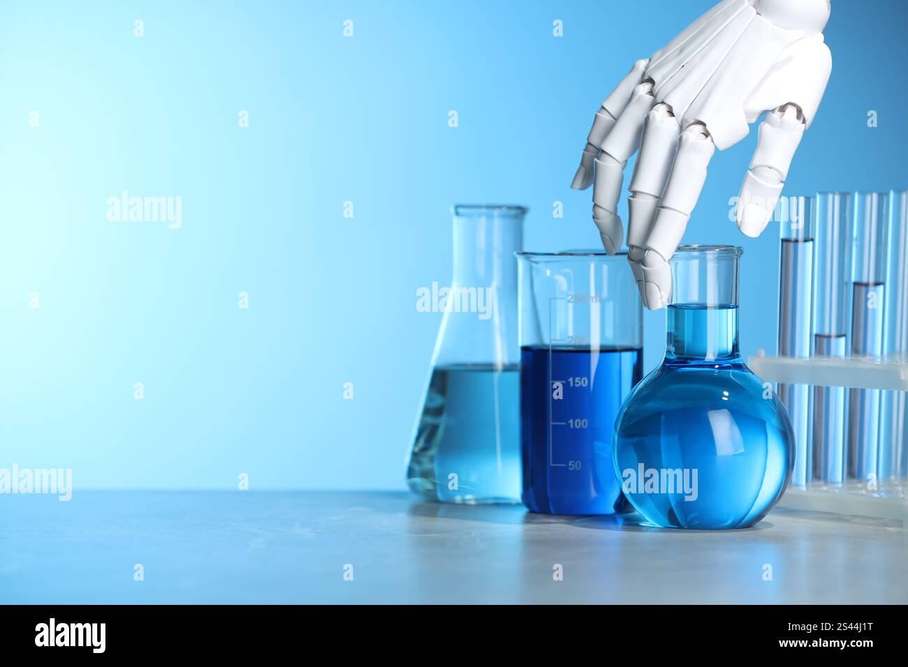 Intelligenza artificiale. Vetreria robot per mani e laboratorio con liquidi sul tavolo su sfondo azzurro, spazio per testo Foto Stock