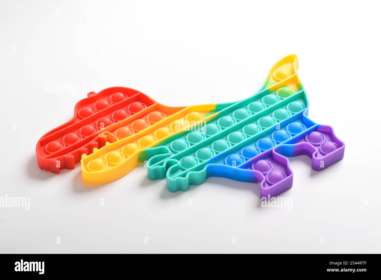 Rainbow Pop IT gioca nei colori arcobaleno e nelle forme dei dinosauri. Coloratissimi giocattoli Fidget sensoriali Push Pop IT Bubble. Gioco anti-ansia e stress Relief Foto Stock