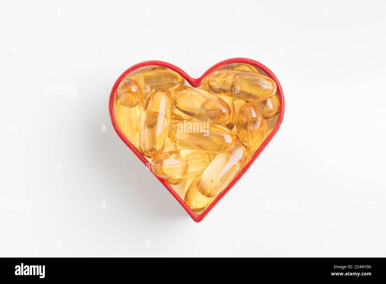 Il cuore è fatto di capsule gialle di vitamina Omega 3 o D su sfondo bianco. Pillole gialle di olio di pesce. Prevenire malattie cardiache e strok ischemico Foto Stock Il cuore è fatto di capsule gialle di vitamina Omega 3 o D su sfondo bianco. Pillole gialle di olio di pesce. Prevenire malattie cardiache e strok ischemico Foto Stock