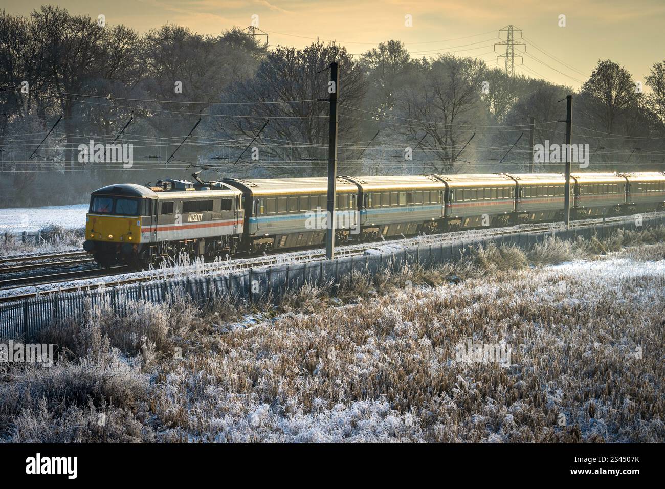 Locomotiva elettrica Royal Sovereign 87002 che trasporta la ferrovia Capitals Scot da Londra a Edimburgo attraverso i campi ghiacciati di Winwick, a ovest Foto Stock