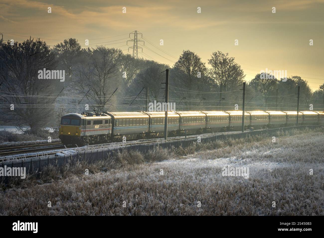 Locomotiva elettrica Royal Sovereign 87002 che trasporta la ferrovia Capitals Scot da Londra a Edimburgo attraverso i campi ghiacciati di Winwick, a ovest Foto Stock